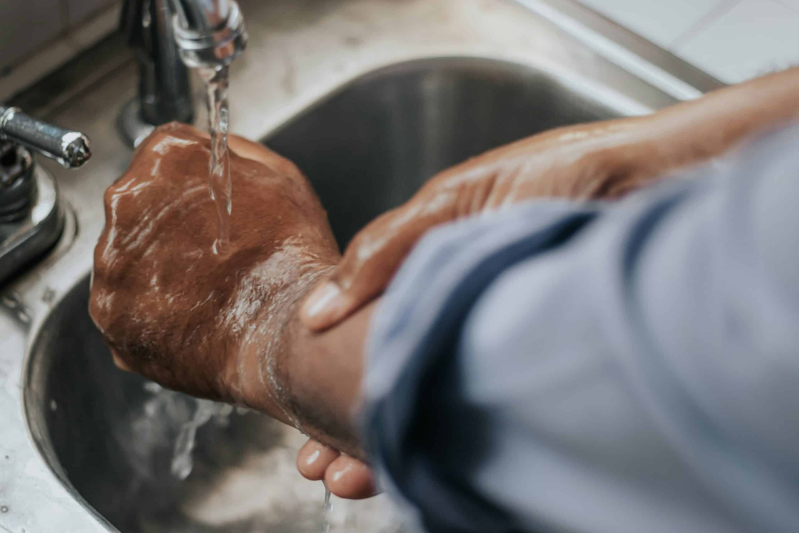 a person rinsing their hand under water